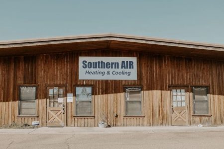 Wooden storefront building with Southern AIR Heating & Cooling signage displayed on the facade above multiple doors and windows.
